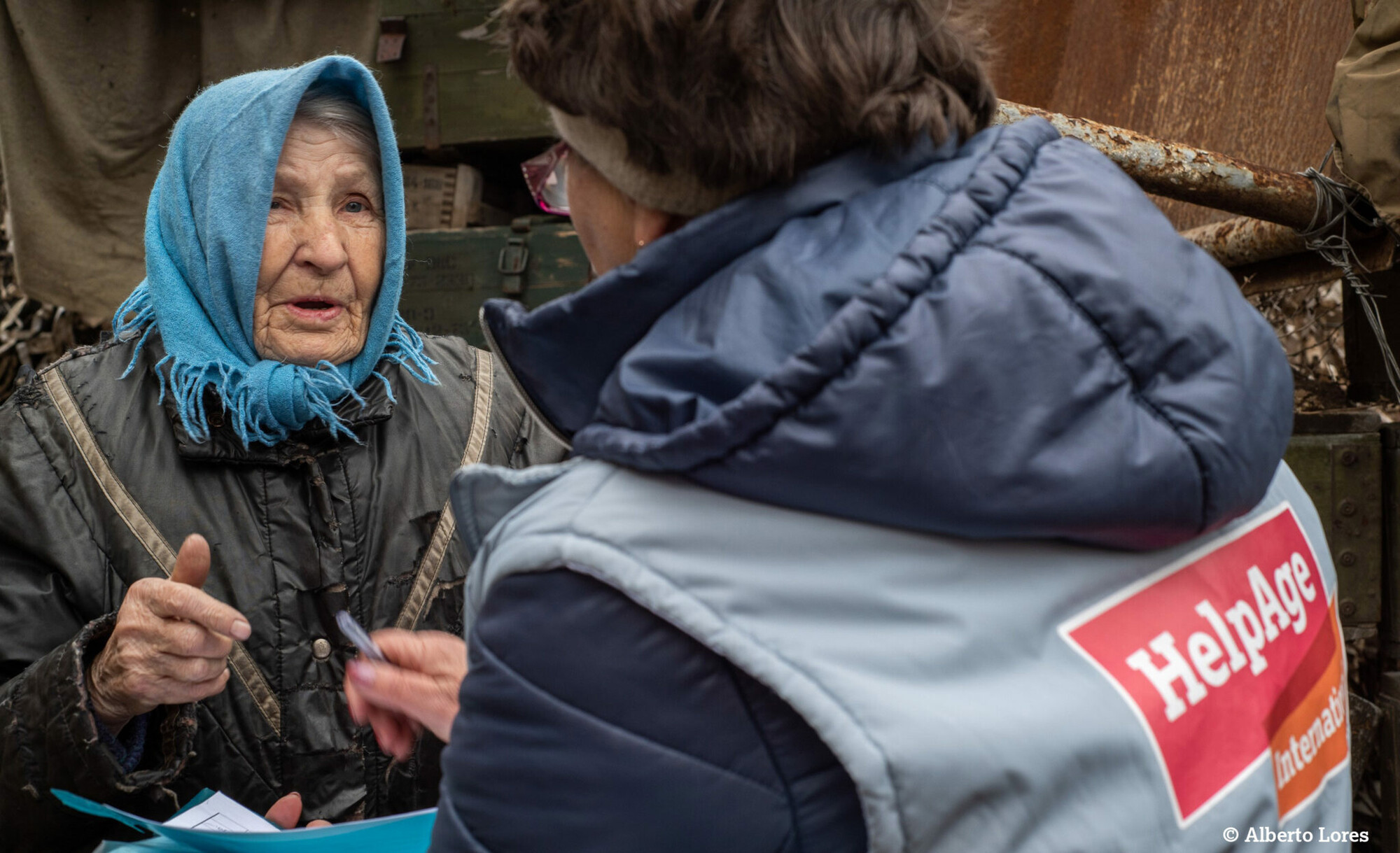 Eine ältere Frau in der Ukraine erzählt einer Mitarbeiterin von HelpAge, was sie benötigt.