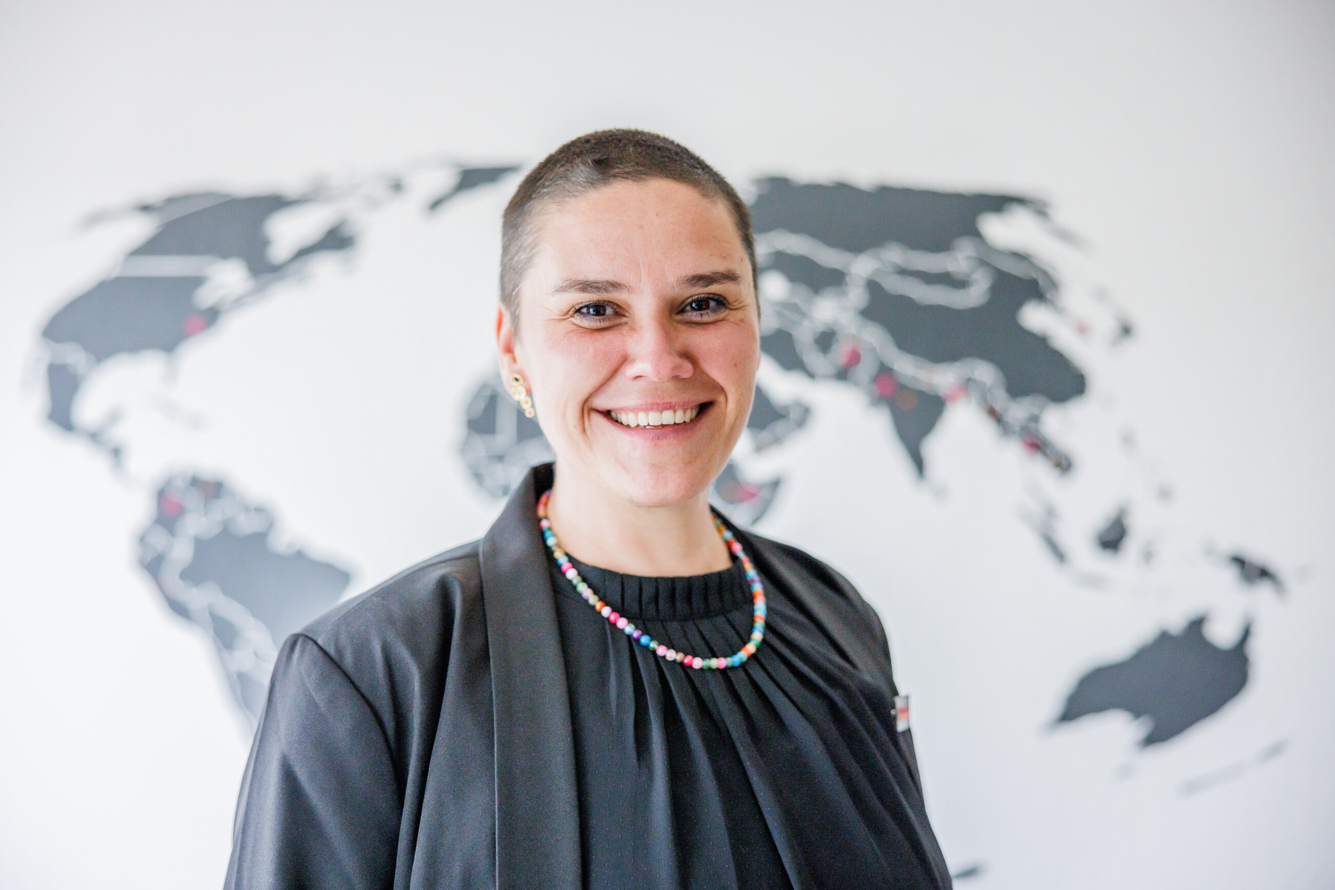 Nadine Fels, neue geschäftsführende Vorständin von HelpAge Deutschland, vor Weltkarte im Büro