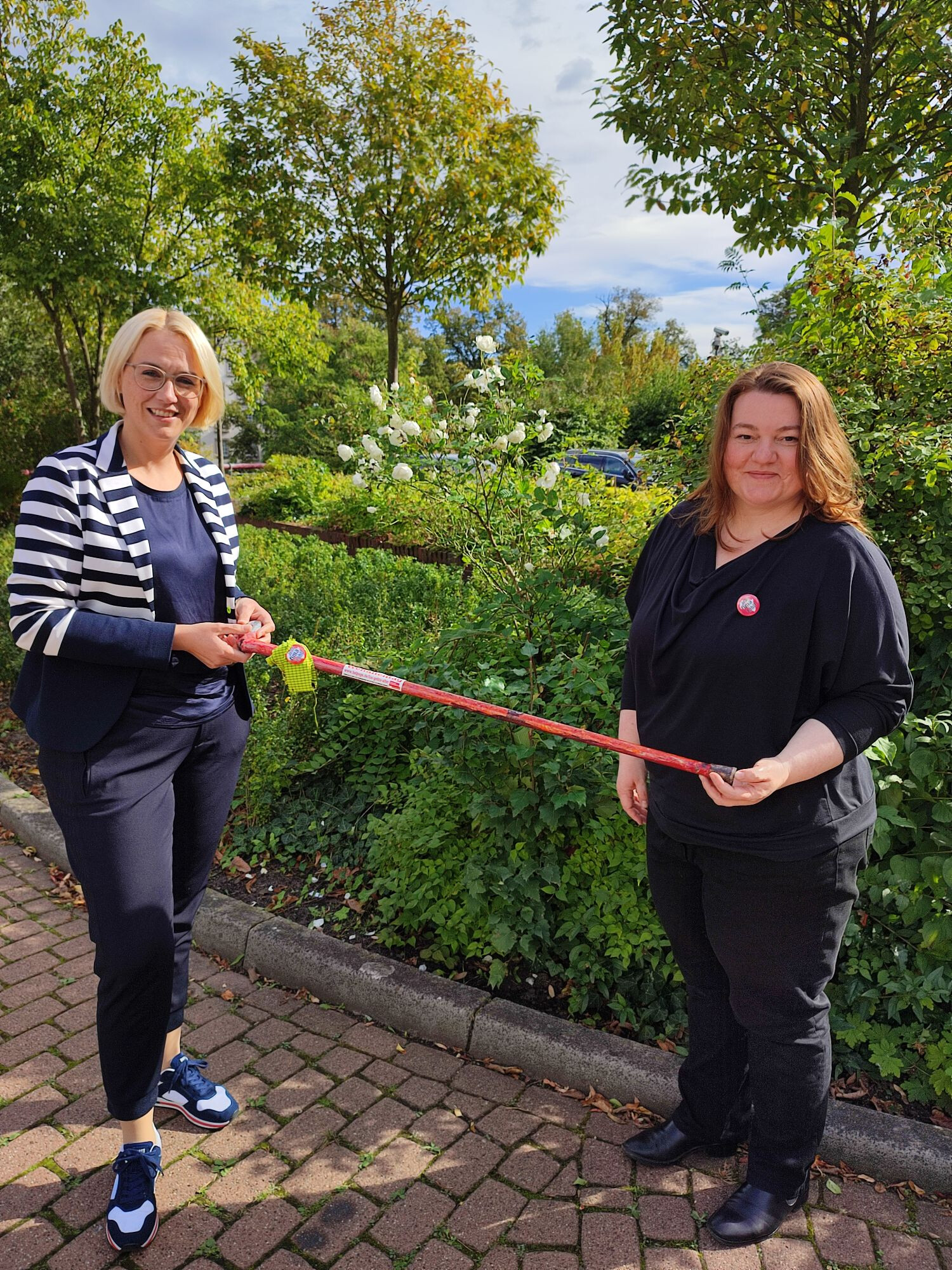 HelpAge-Geschäftsführerin Sonja Birnbaum überreicht der künftigen Oberbürgermeisterin von Osnabrück Katharina Pötter zum Weltaltentag einen bunt gestalteten Gehstock.