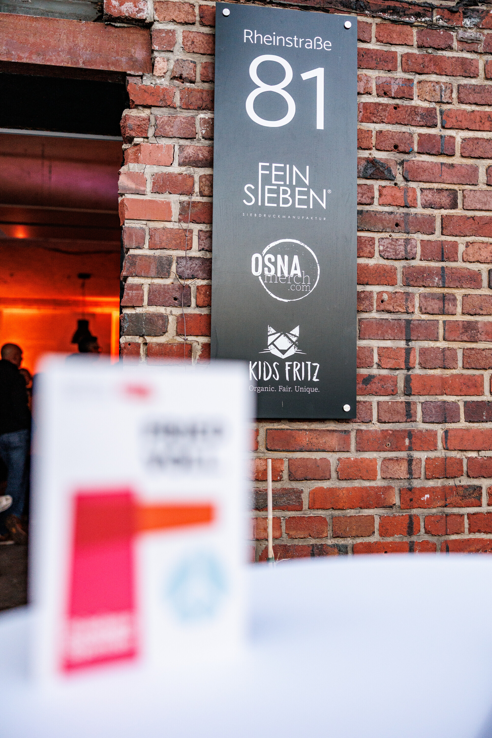 Schild an einem Gebäude mit Logos von Firmen.