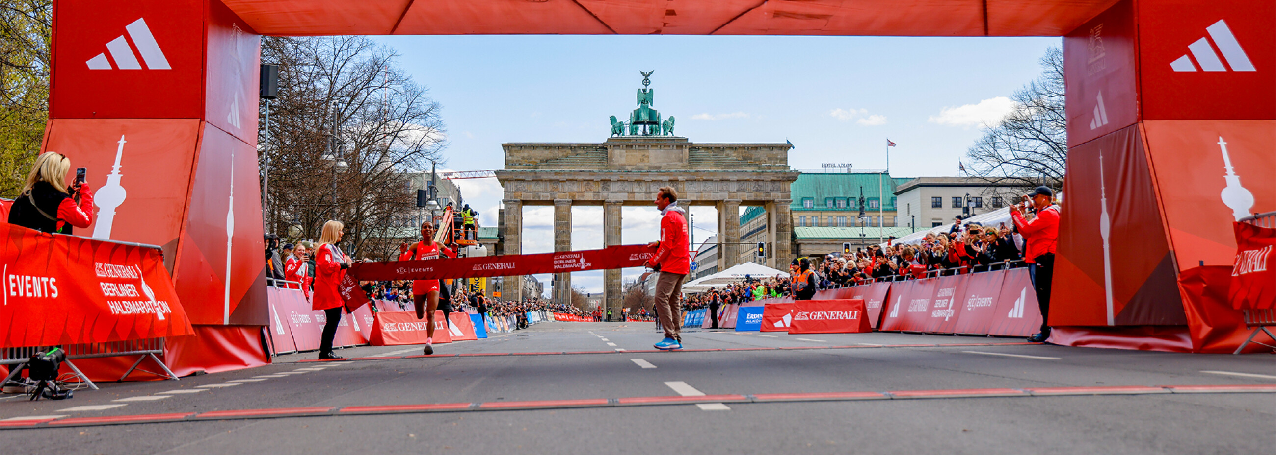 Frau läuft in das Ziel eines Halbmarathons ein