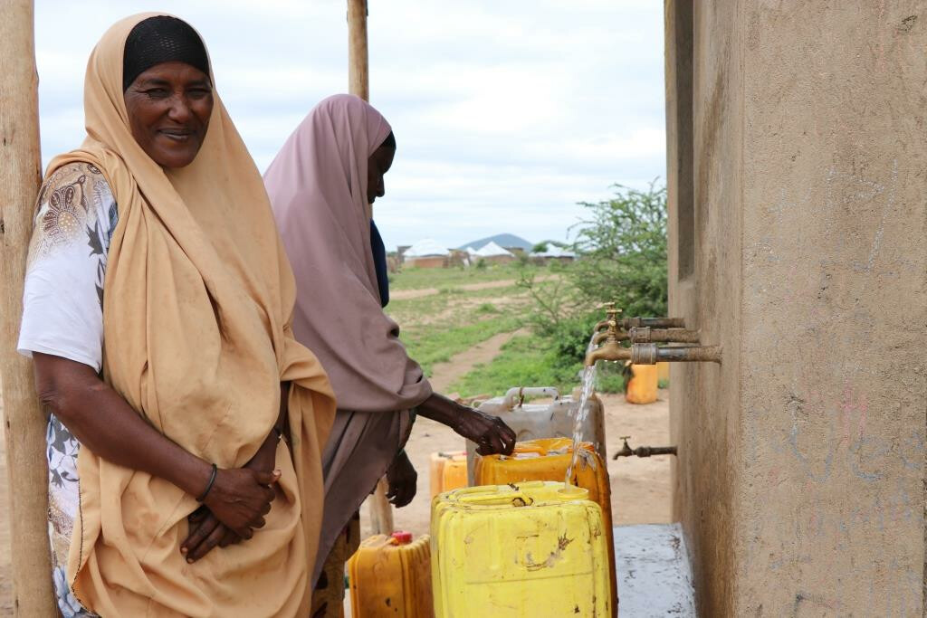Eine Frau steht mit ihrem Kanister an einer neu gebauten Wasserstelle in Äthiopien.