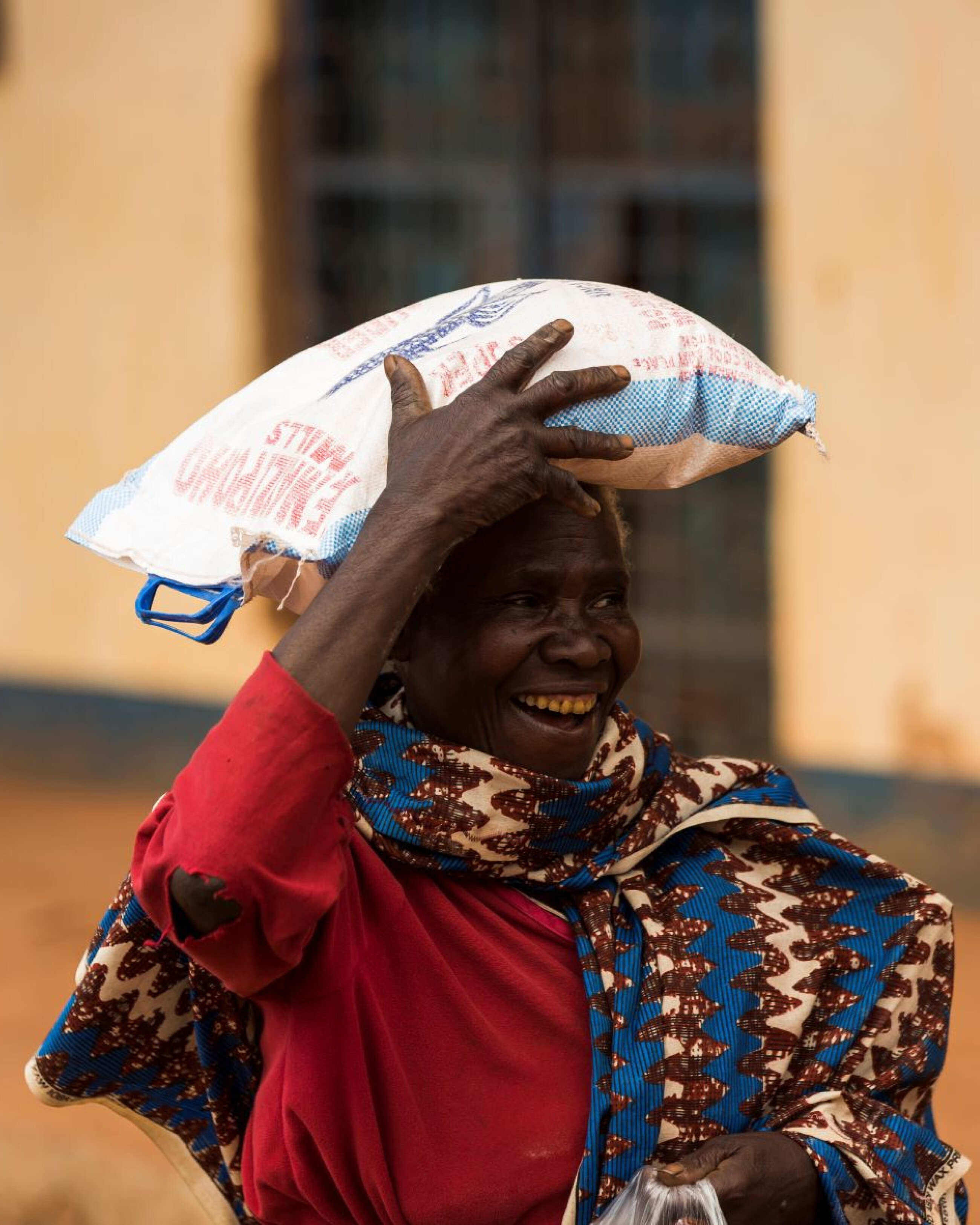 Person trägt einen Sack auf ihrem Kopf und lächelt dabei