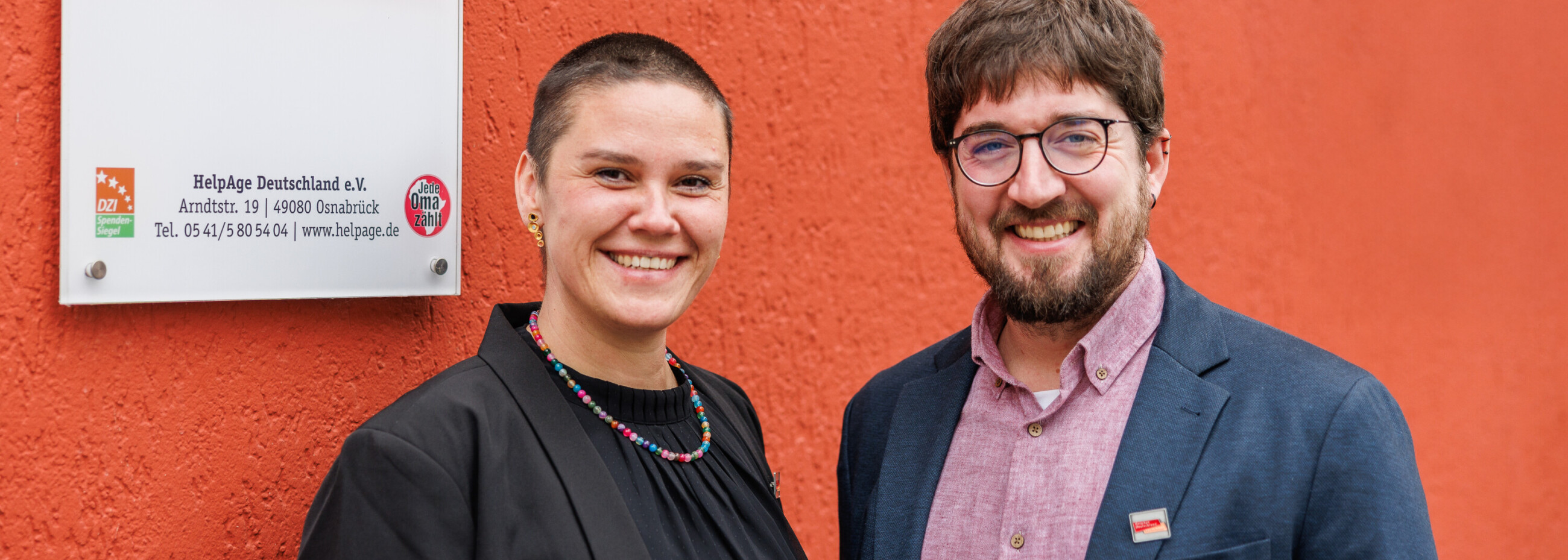 Nadine Fels und Dr. Tom Kafczyk vor dem HelpAge Deutschland-Schild am Standort Osnabrück.