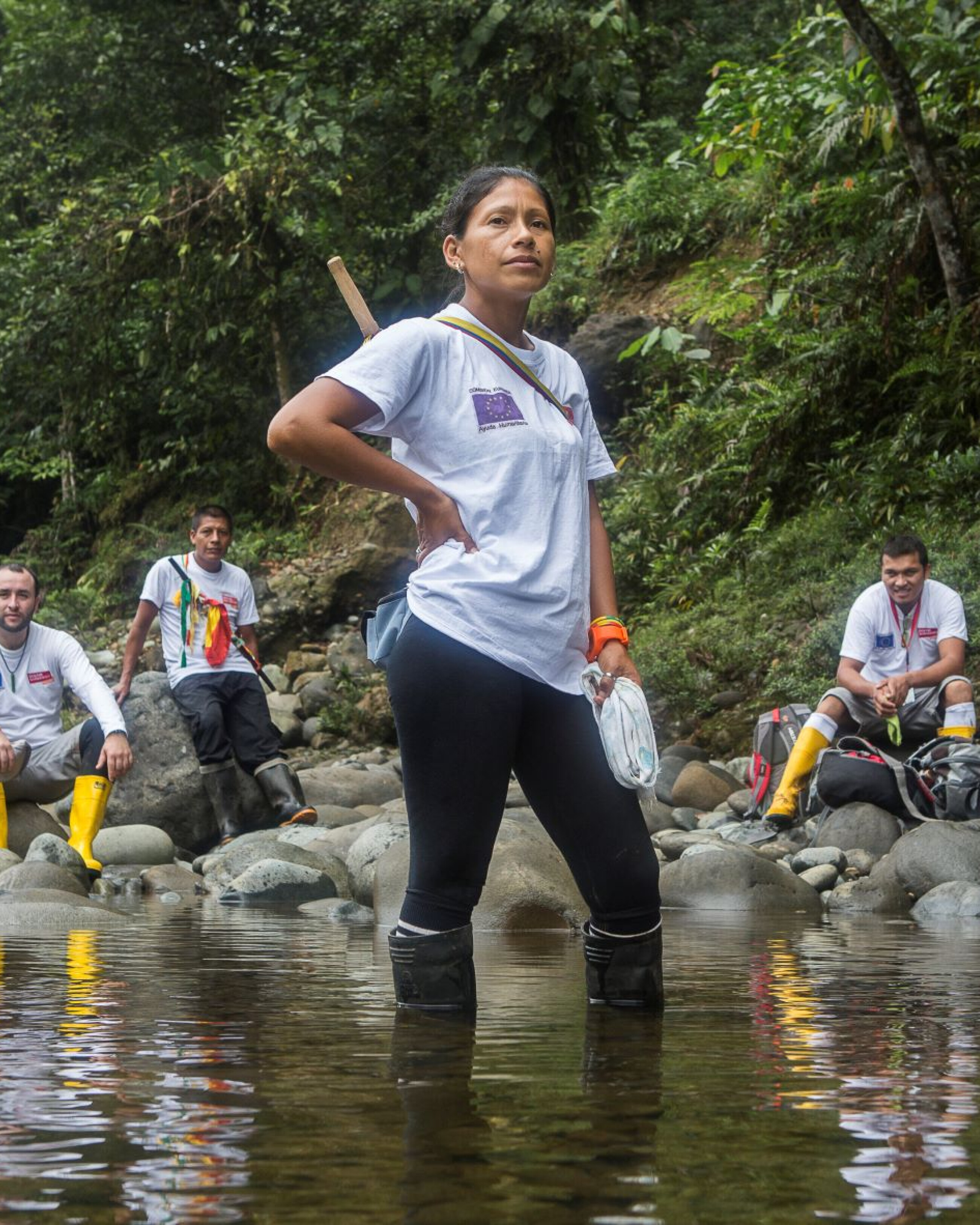 Frau steht im Fluss und im Hintergrund sind weitere Menschen